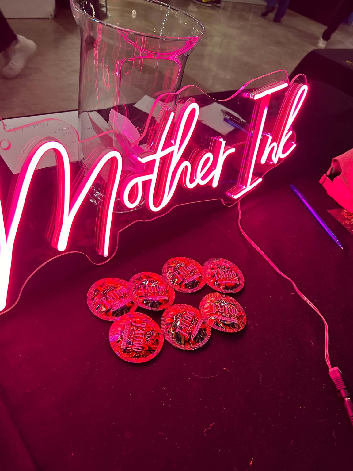 The Mother Ink neon sign at a community event